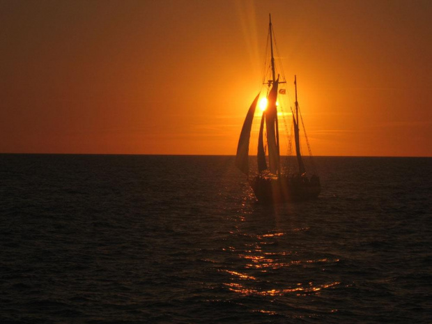 Zdjęcie statku na tle zachodu słońca podczas wieczornego rejsu po spokojnym morzu. #morze #ZachódSłońca #statek #zachód #słońce #rejs